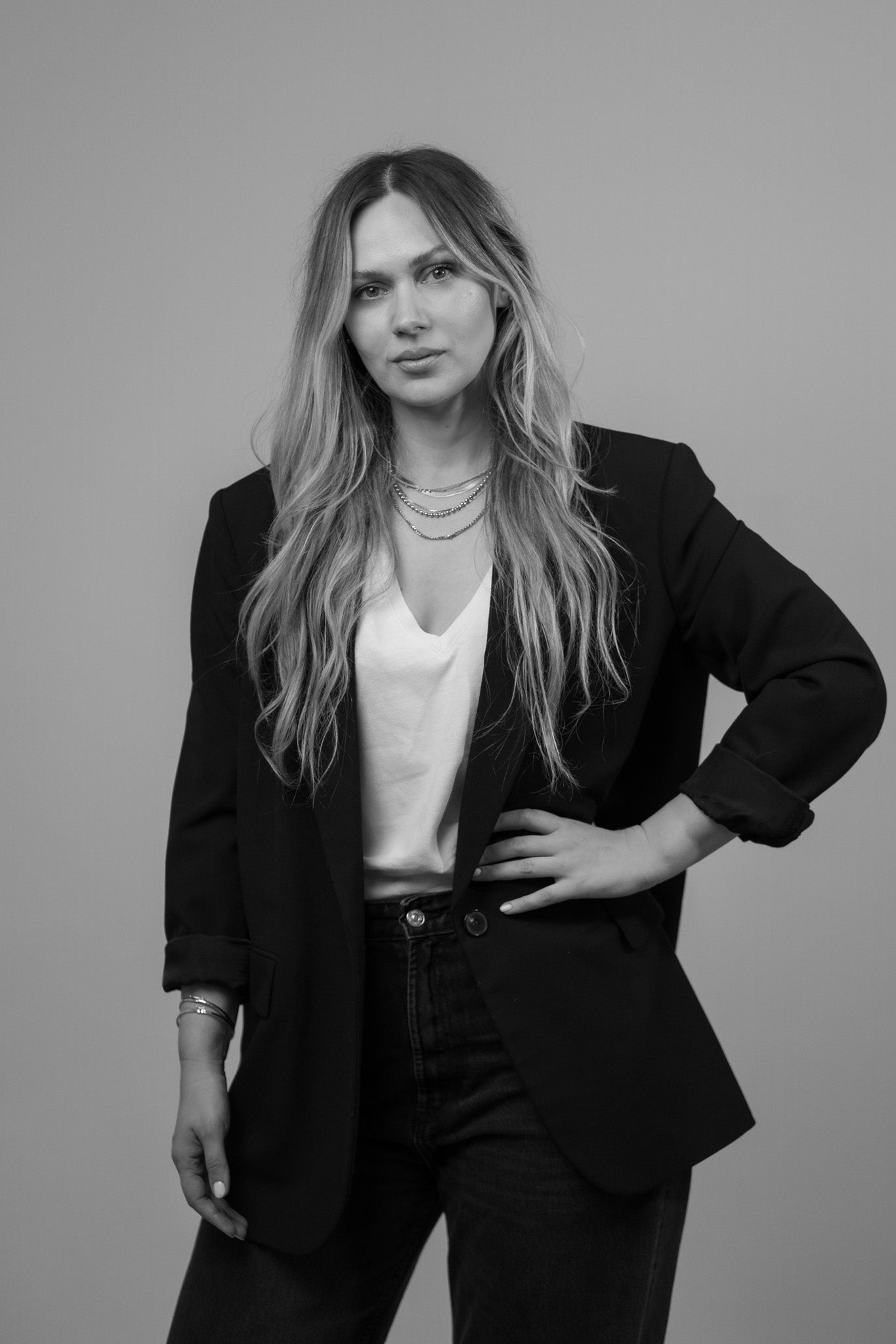 Black and white portrait of Emina, the founder and creative force behind E MINA OBJECTS, posing with confidence against a neutral background.