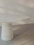 Leila Table in Roman travertine highlighting the tabletop profile and monolithic cone base