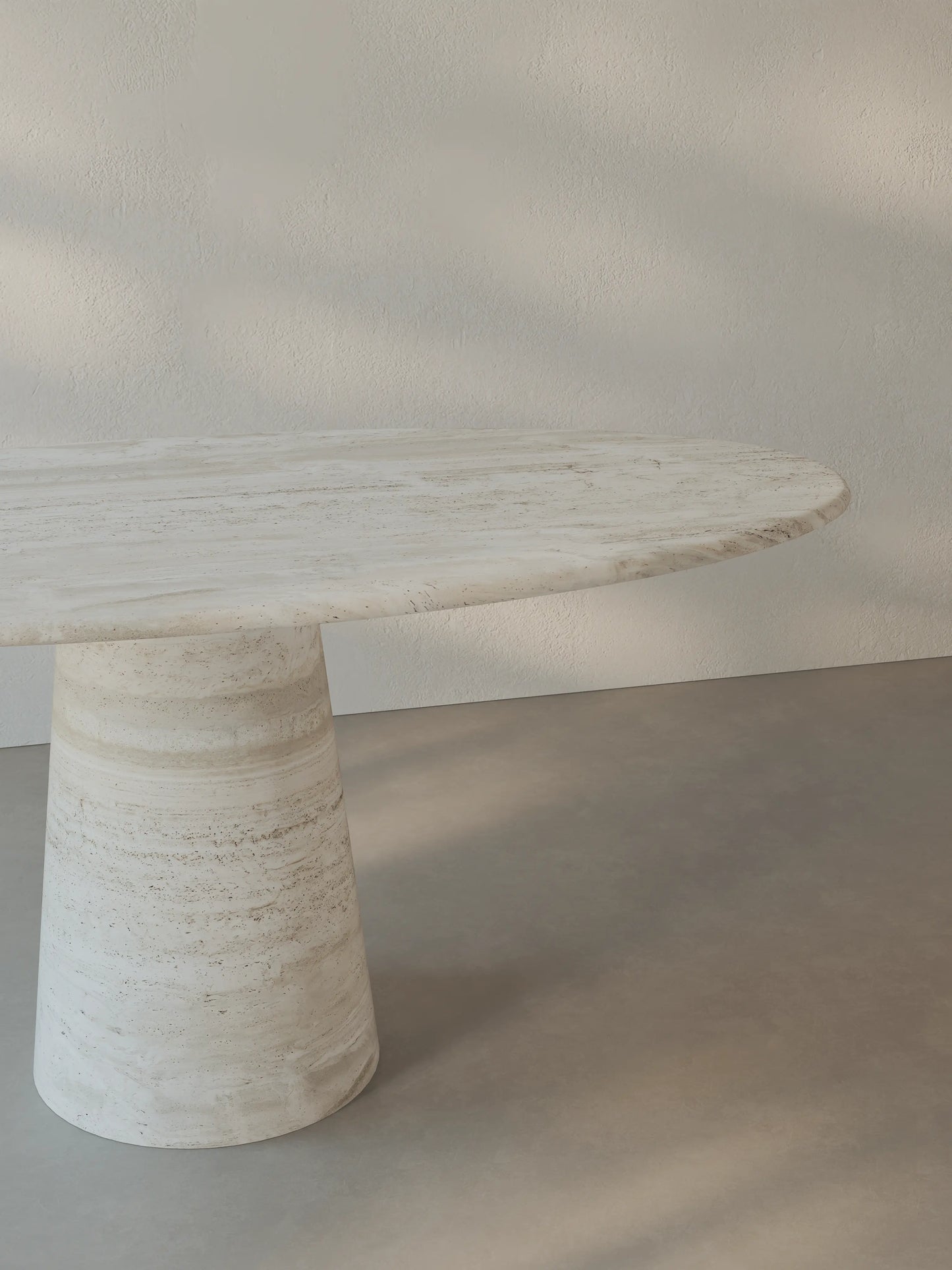 Leila Table in Roman travertine highlighting the tabletop profile and monolithic cone base