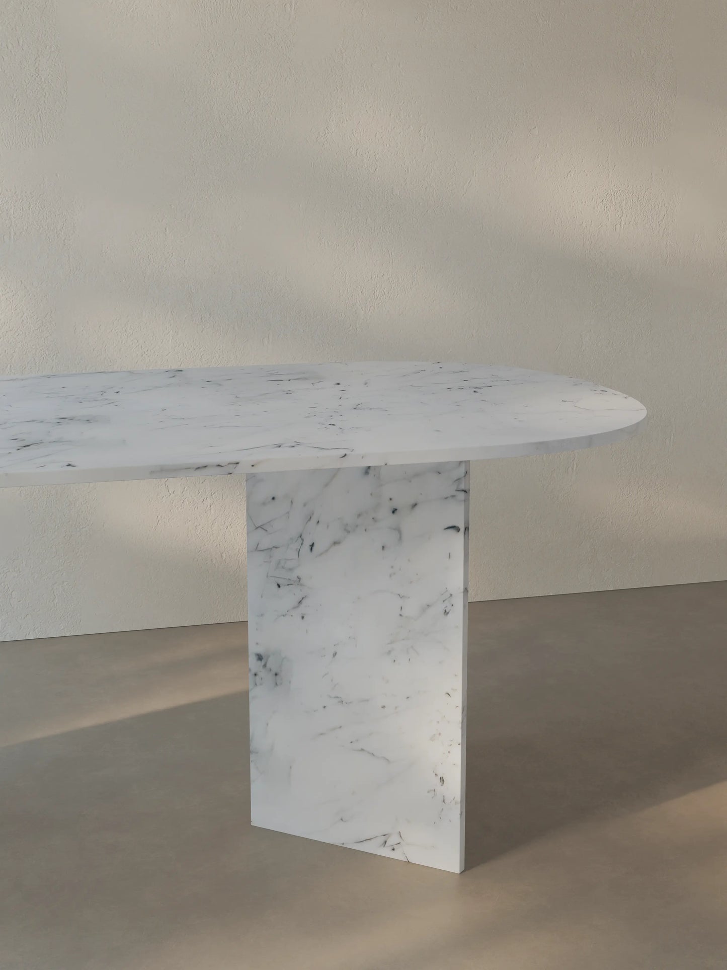 Side view of the Sienae Dining Table in Carrara Bianco marble showing the sculptural V-shaped base