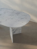 Detail view of the oval-edged tabletop of the Sienae Dining Table in Carrara Bianco marble