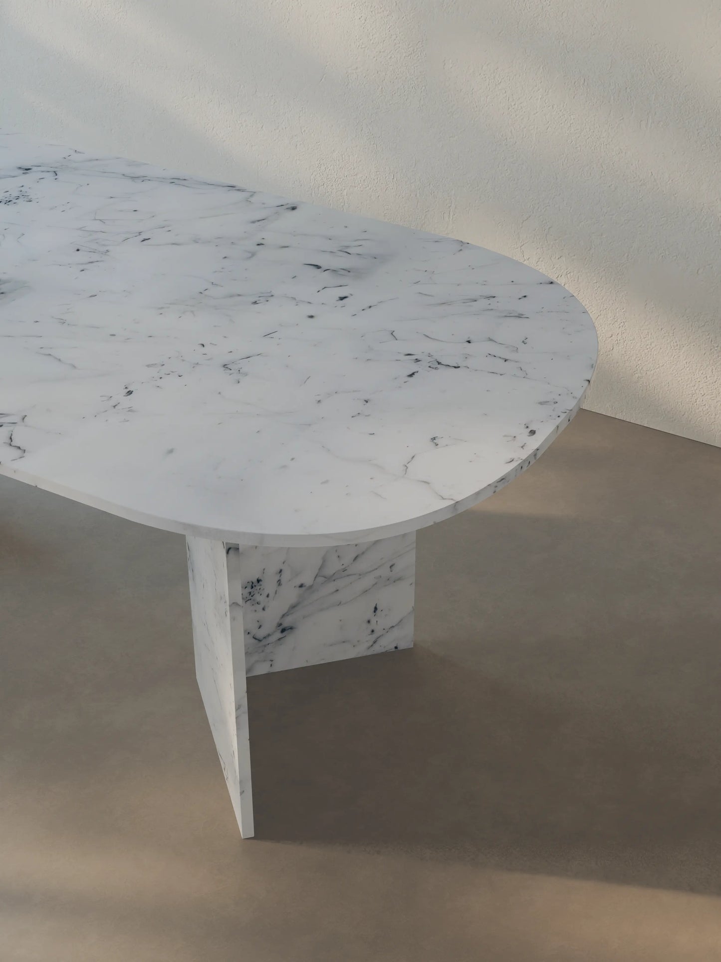 Detail view of the oval-edged tabletop of the Sienae Dining Table in Carrara Bianco marble
