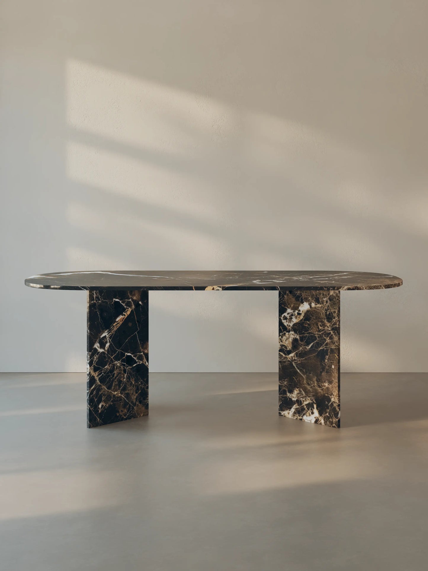 Sienae Dining Table in Dark Emperador marble with oval-edged tabletop and sculptural V-shaped base, shown from the front