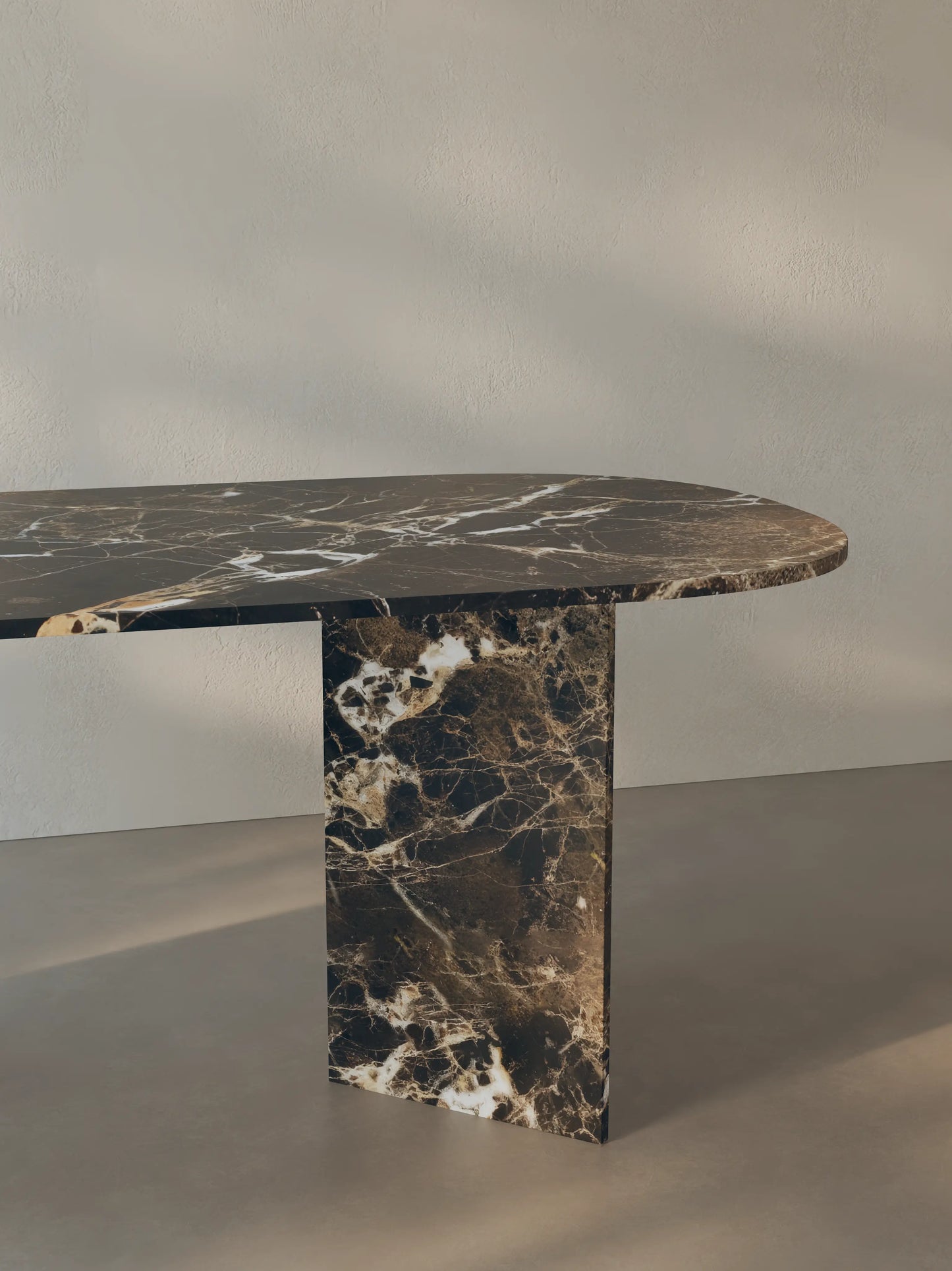Side view of the Sienae Dining Table in Dark Emperador marble showing the sculptural V-shaped base