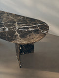 Detail view of the oval-edged tabletop of the Sienae Dining Table in Dark Emperador marble