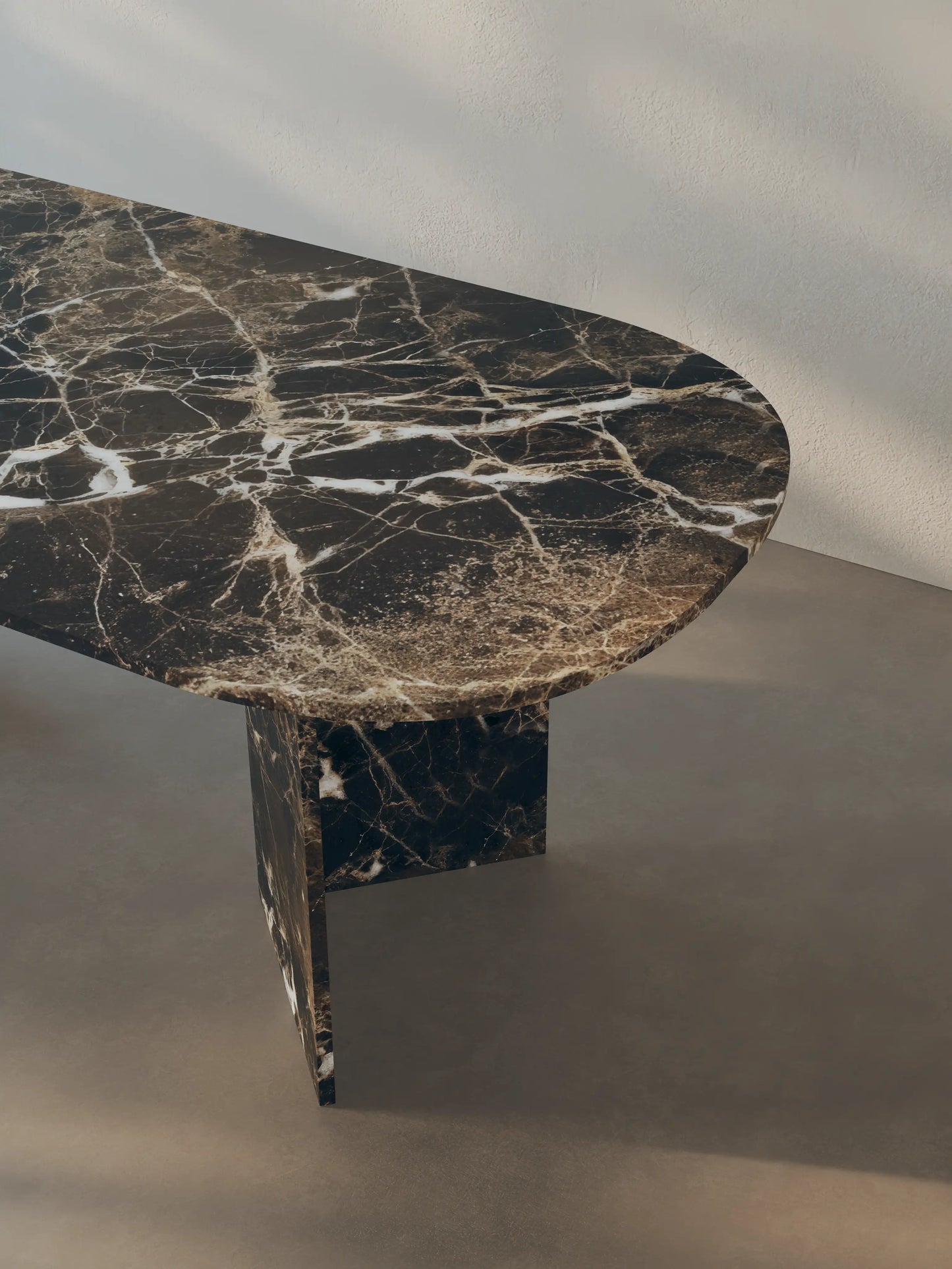 Detail view of the oval-edged tabletop of the Sienae Dining Table in Dark Emperador marble