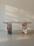 Sienae Dining Table in Rosso Orobico marble with oval-edged tabletop and sculptural V-shaped base, shown from the front