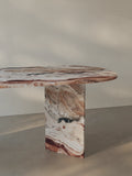 Detail view of the oval-edged tabletop of the Sienae Dining Table in Rosso Orobico marble