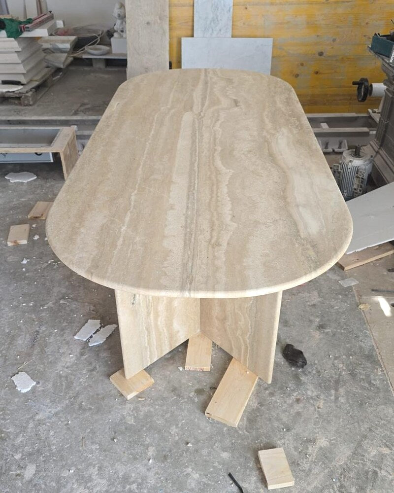 Custom travertine table with an intersecting base in the workshop.